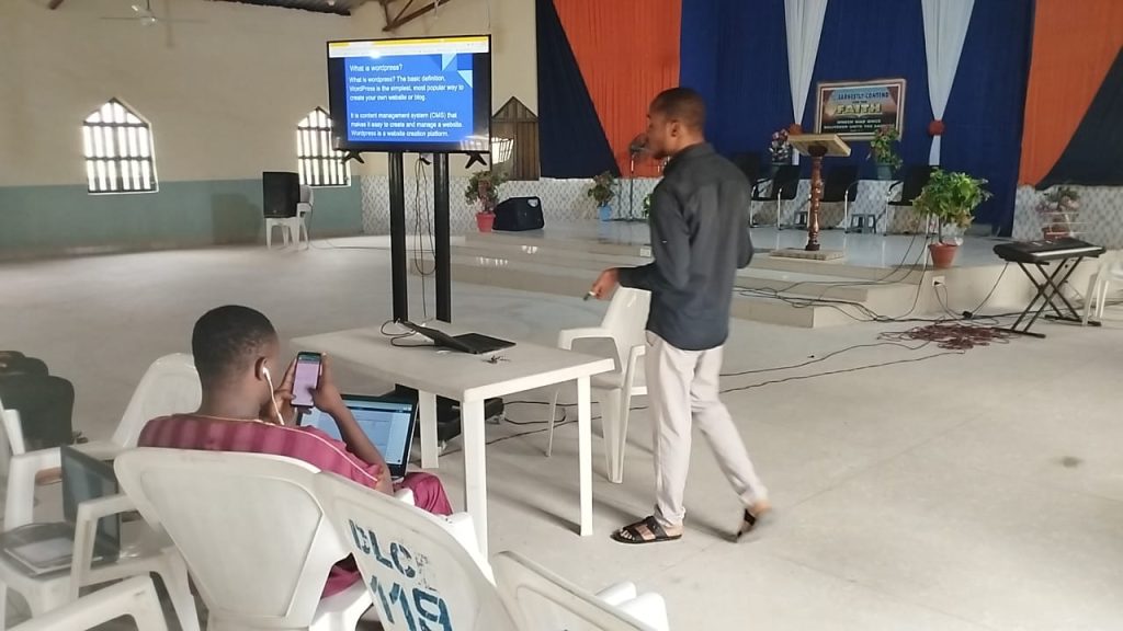 Chidiebere teaching holding a wordpress class in 2022. Chidiebere is on black shirt and milk coloured trousers 
